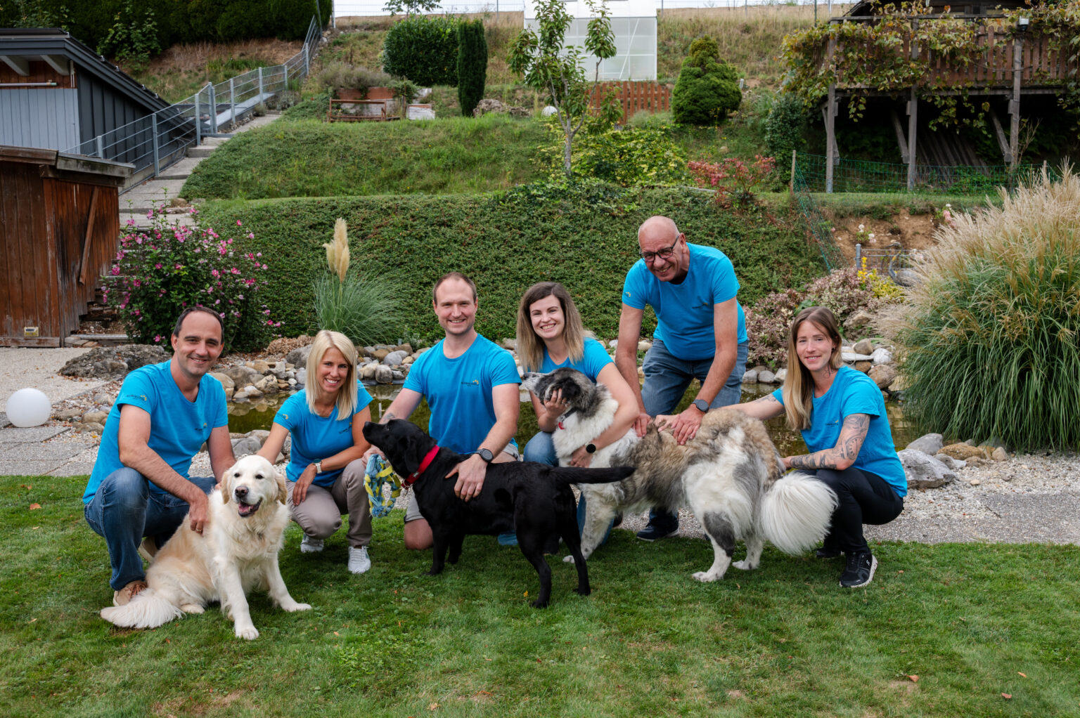 About us The SCHNAUZERL team with dogs by the pond